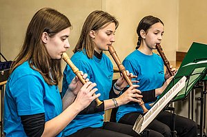 Blockflötenensemble aus 3 Personen bei der Probe mit Flöten von Sopran bis Alt