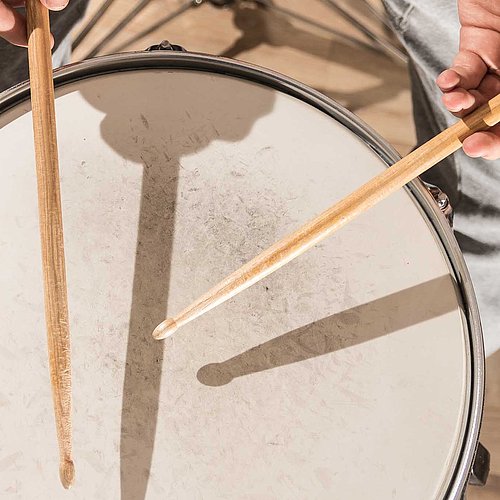 Spielende Hände mit Drumsticks auf einer Snaredrum