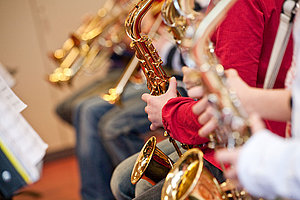 Jugendliche spielen Saxophone und Trompeten im Orchester